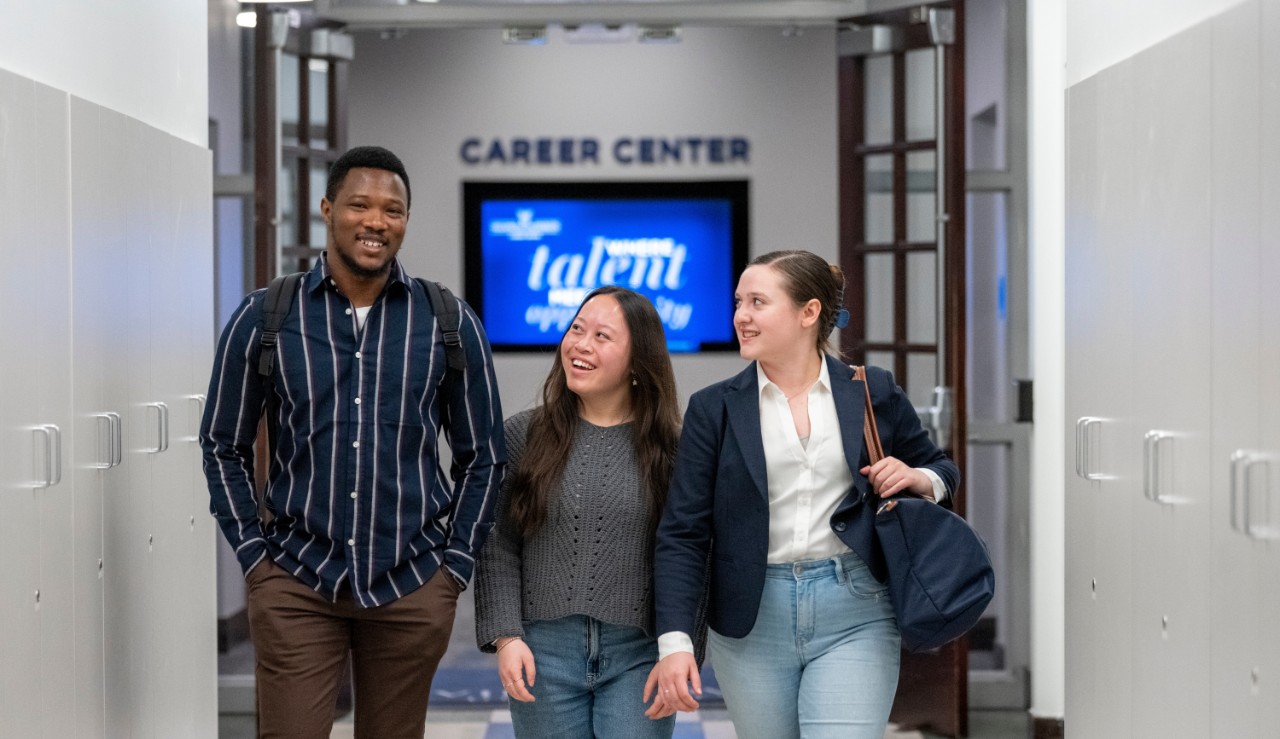 Three students walking out of the entrance of the career center.