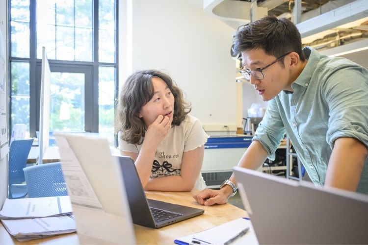 Chenfeng Xiong works with a student at a computer