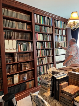 Dr. Bauer searches for a book on one of the bookcases in his home library. His collection of 20,000 herpetology texts—and his knowledge of each of them—are inavulable and otherwise inacessible resources for students.