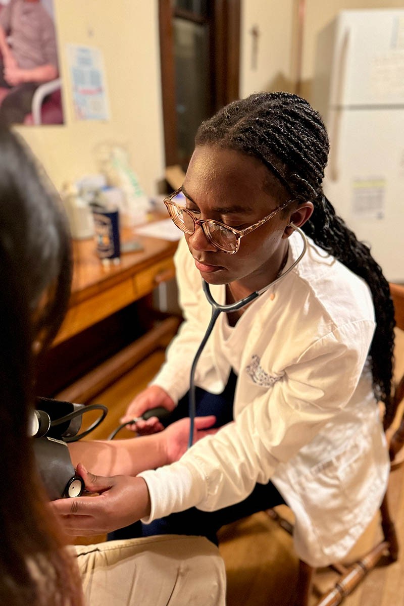 A student volunteer taking vitals