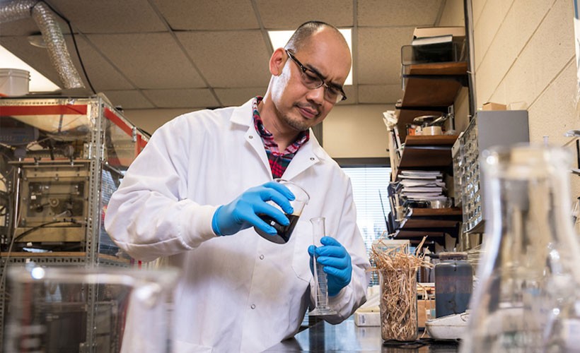 Professor pouring liquid into tube