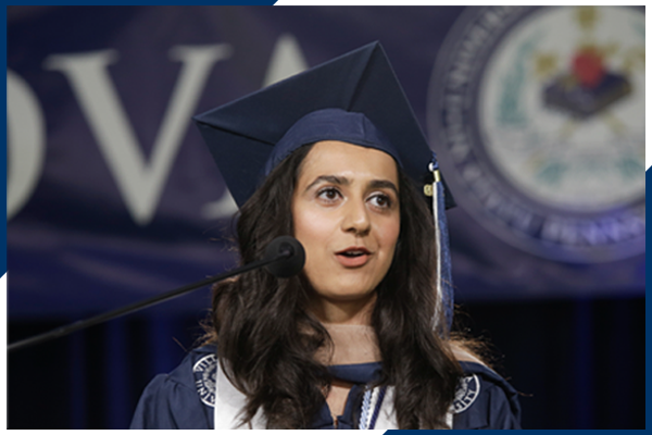 student at podium in cap and gown