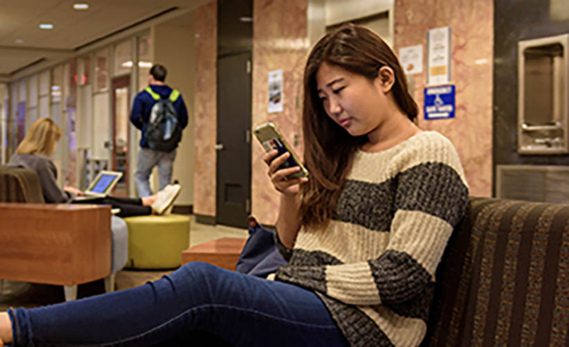 Student checking cell phone for Nova Alert.