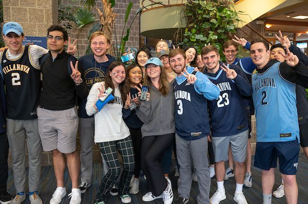 Students gathered together enjoying a Villanova basketball game. 
