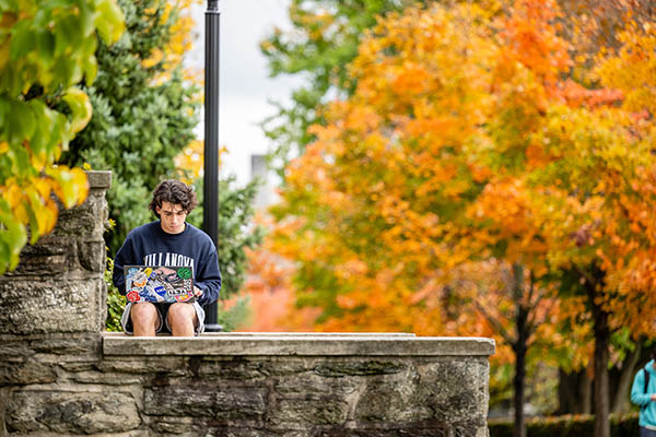 A student works on a computer outside.